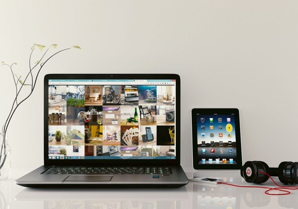 编辑在笔记本电脑前逐条核对秒玩小游戏在线玩的分类清单，屏幕上是网格状的游戏条目，暖色台灯照亮记录本上的手写批注